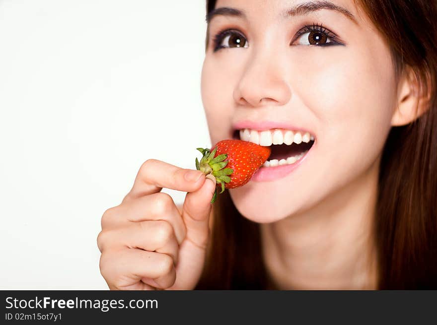 Cheerful picture of an attractive young woman biting a strawberry. Cheerful picture of an attractive young woman biting a strawberry