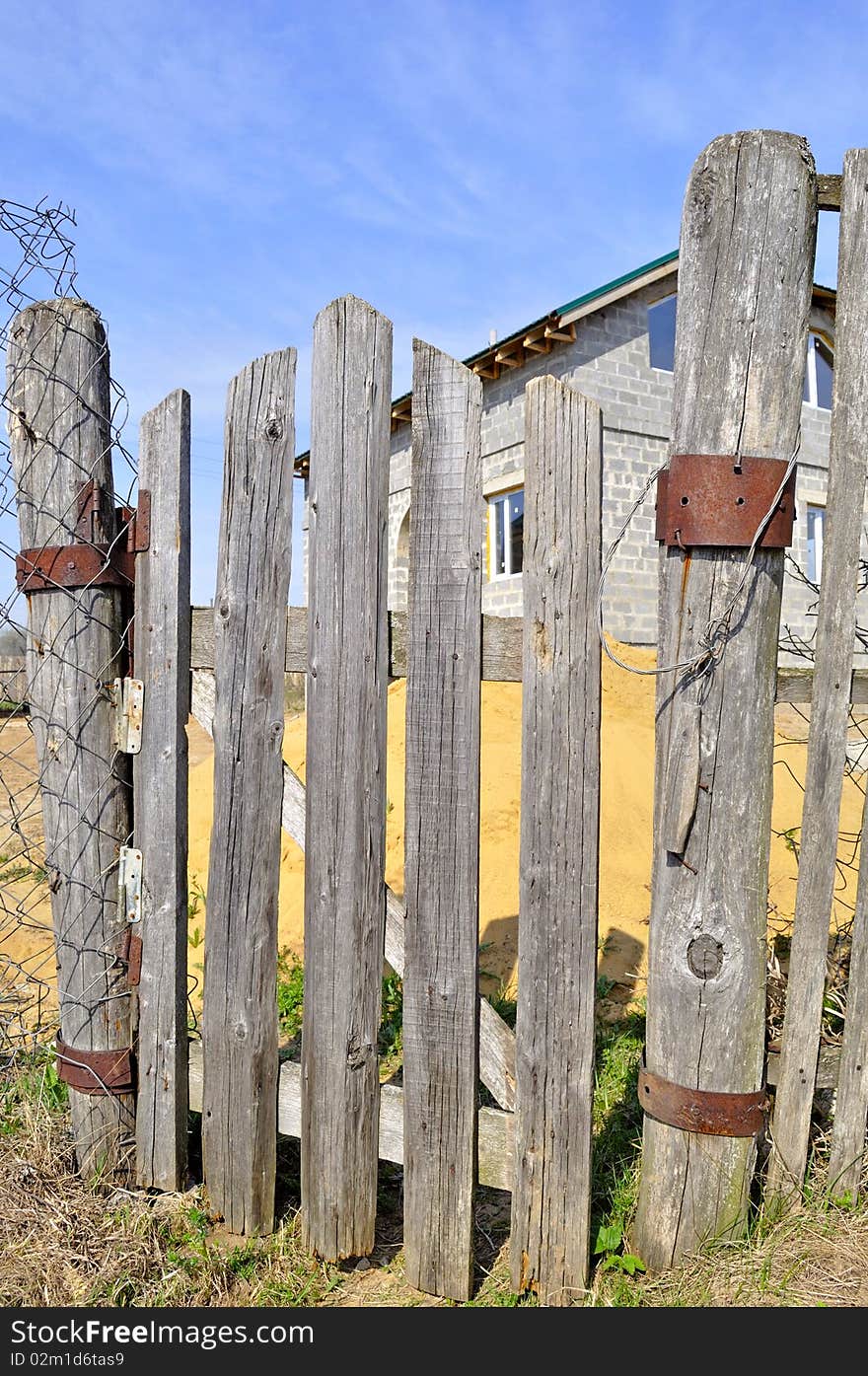 The old wooden lop-sided gate to the house. The old wooden lop-sided gate to the house