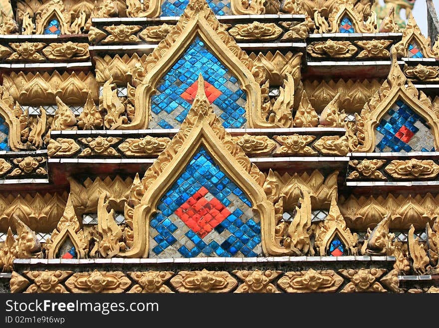 Details of traditional Thai art on base of church.