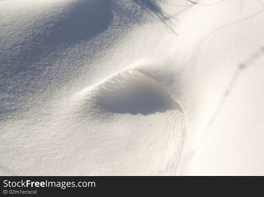 Shadows on a small snow drift.