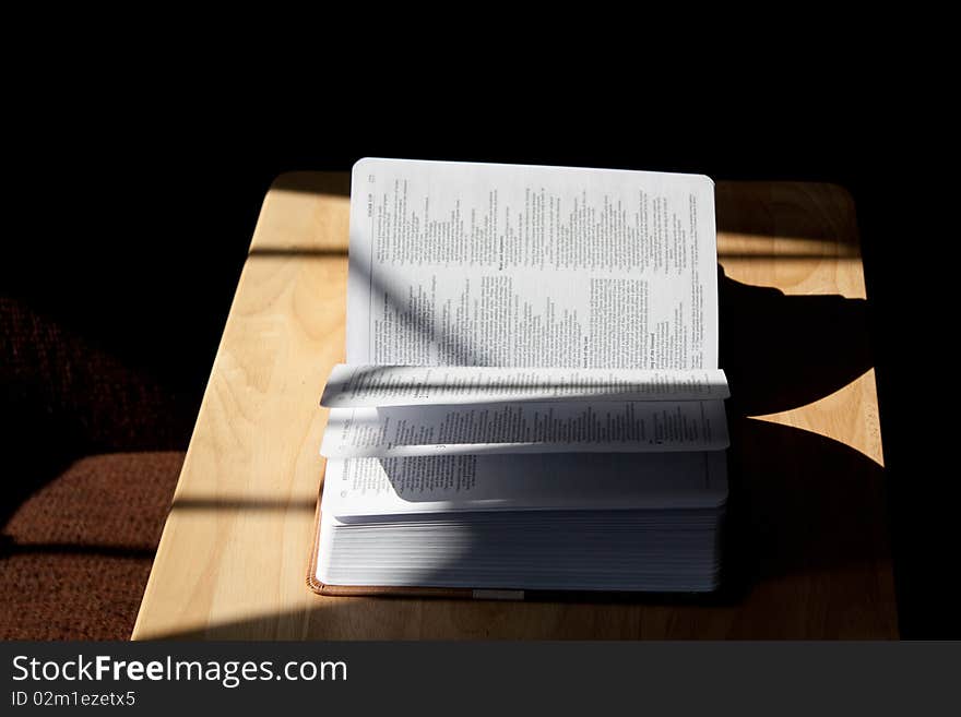 An open Bible in a shadow.