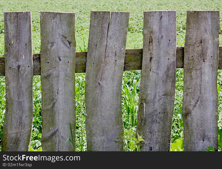 Rural  wooden fence on a grass background