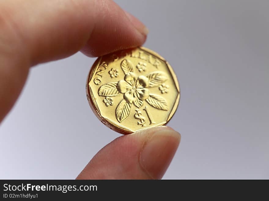 Hand with One singapore coin.