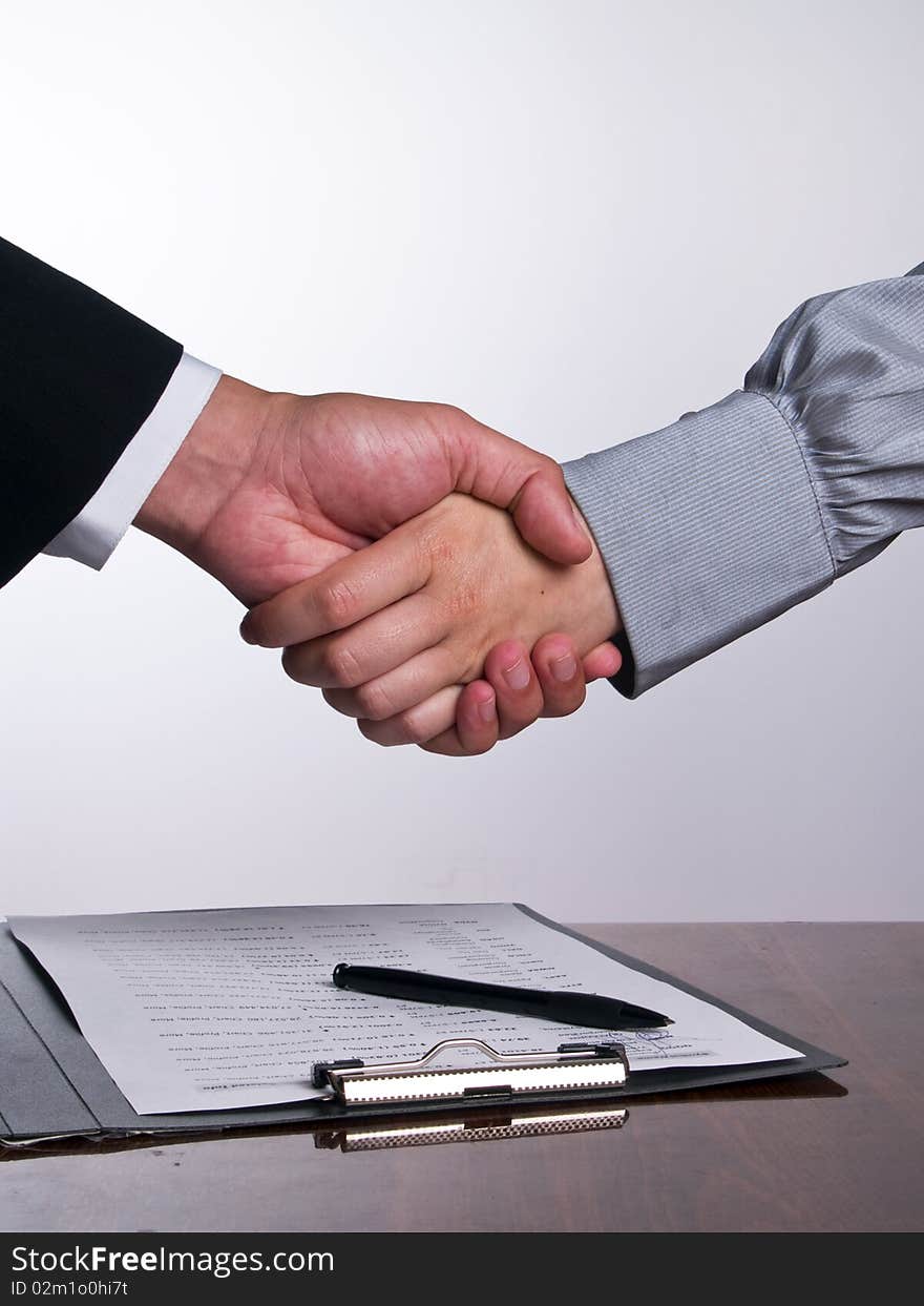 Business people in the office shaking hands after sign up the contract (vertical align). Business people in the office shaking hands after sign up the contract (vertical align)