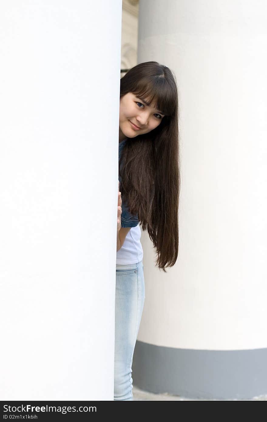 Girl hiding behind column outdoor