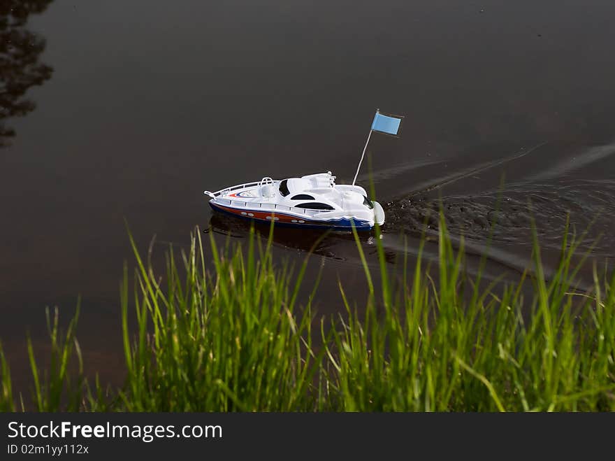 Toy motor boat floating on the river