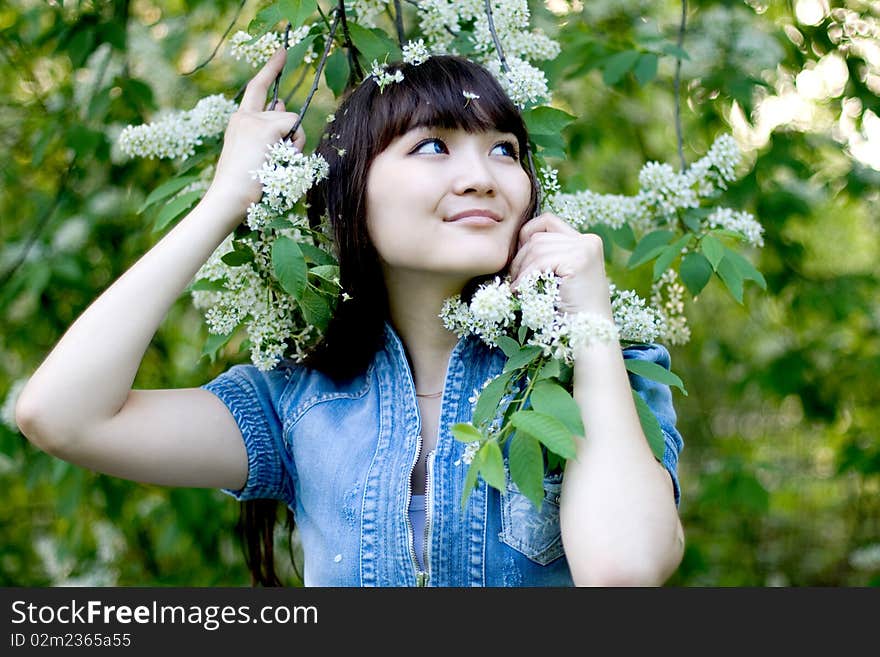 Girl standing near lilac in blossom