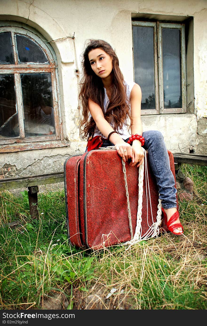 Bored girl with red suitcase.