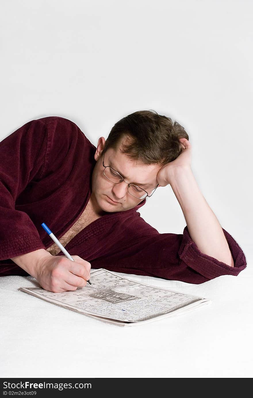 The man in a dressing gown with a crossword puzzle