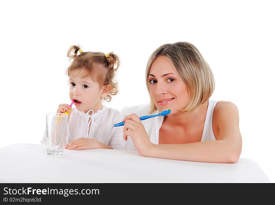 Young mother and her young daughter brush their teeth on a white background