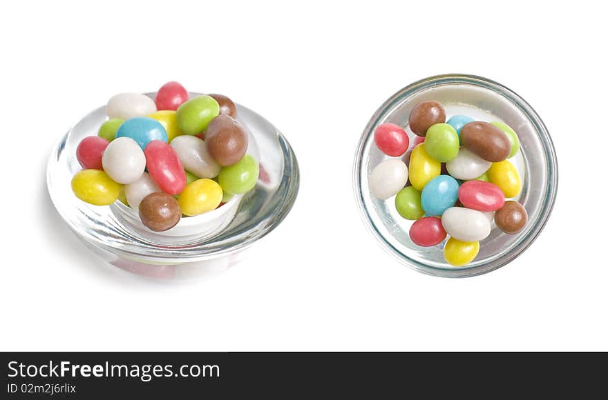 Multicolored shugar sweets in glass isolated on white background. Multicolored shugar sweets in glass isolated on white background