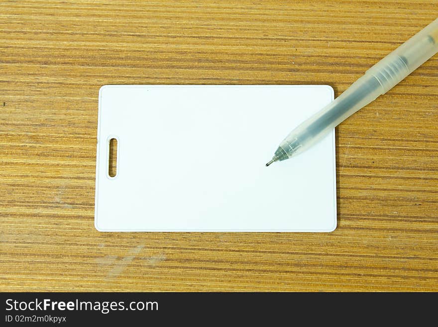 White card and the pen on the wood table. White card and the pen on the wood table