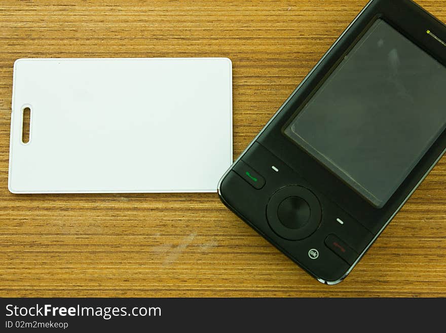 White card and black mobile on the wood table