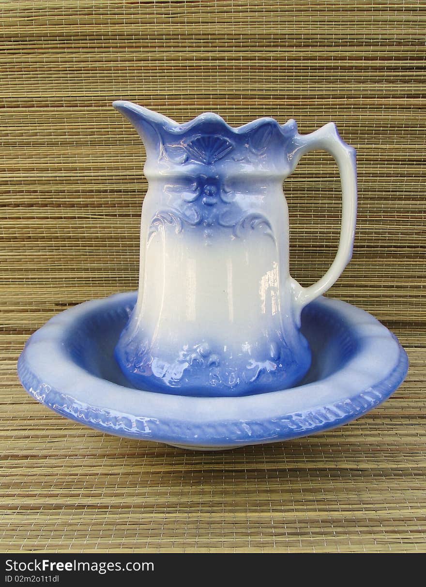 Blue pitcher and bowl set with straw background