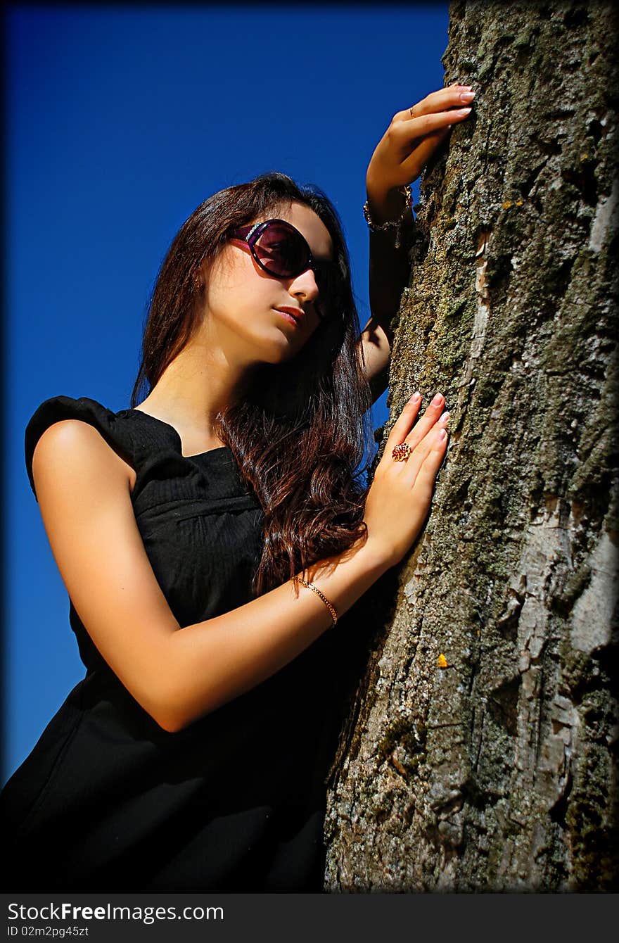 Charming Lady In Black Next To A Tree.