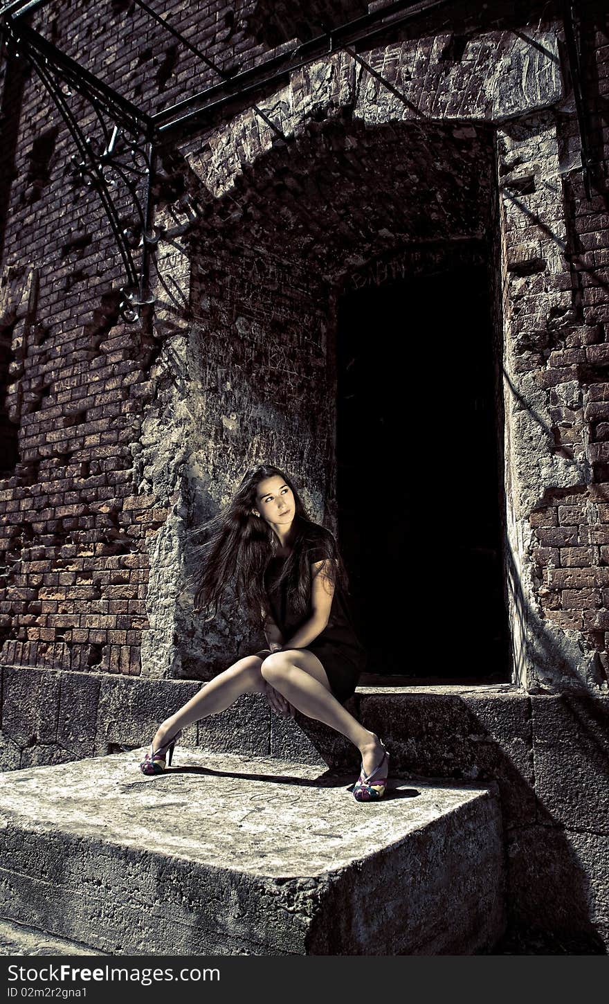 Charming Lady In Black Dress Sitting On Staircase.