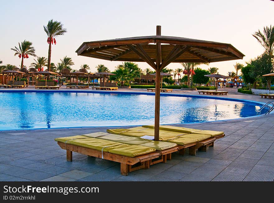 The sunbed next to swimming pool. The sunbed next to swimming pool.