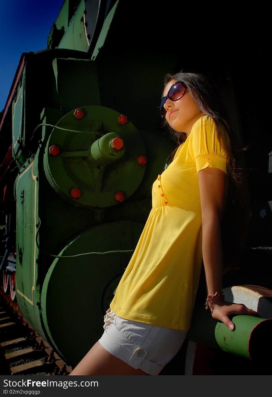 Girl in glasses with train on background.