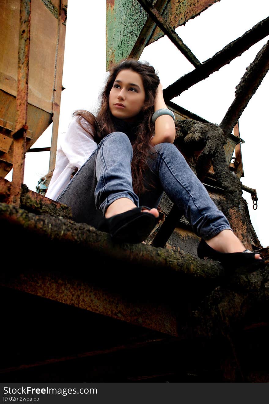 Beautiful girl sitting in an old factory.