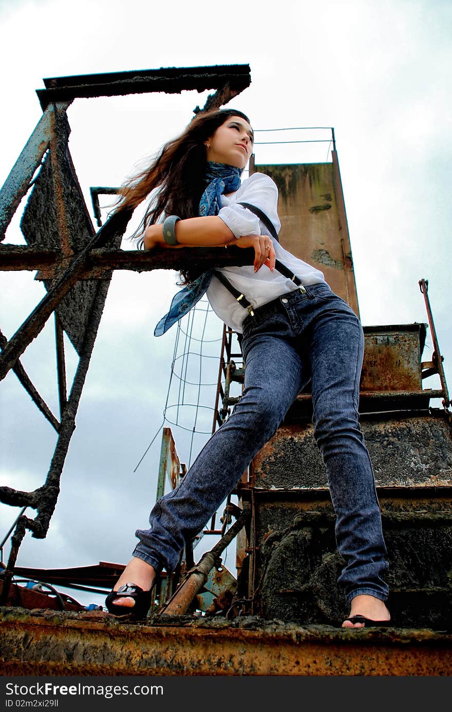 Beautiful girl stanging in an old factory.