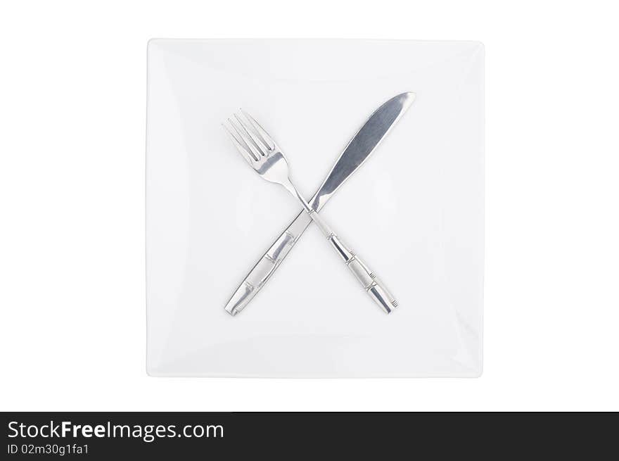 Fork and knife on a squared plate isolated. Fork and knife on a squared plate isolated