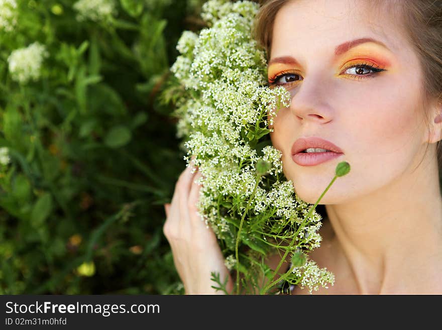 Young beautiful woman with bright makeup and white flowers. Young beautiful woman with bright makeup and white flowers