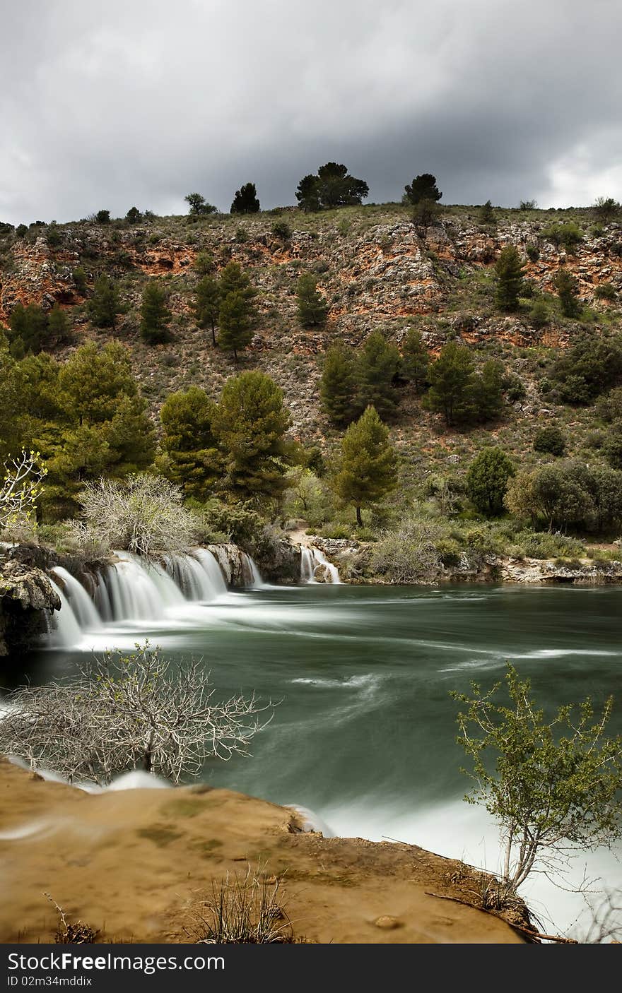 Waterfall in a birth of a river in the autumn with the trees without leaves. Waterfall in a birth of a river in the autumn with the trees without leaves