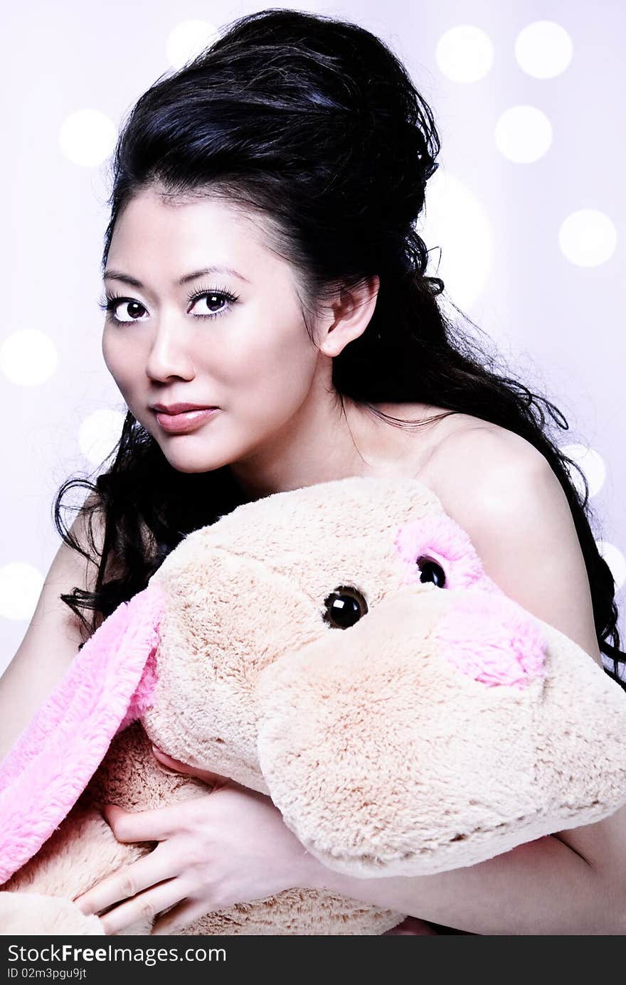 Long hair Asian girl holding a furry stuff animal and smiling to the camera. Long hair Asian girl holding a furry stuff animal and smiling to the camera