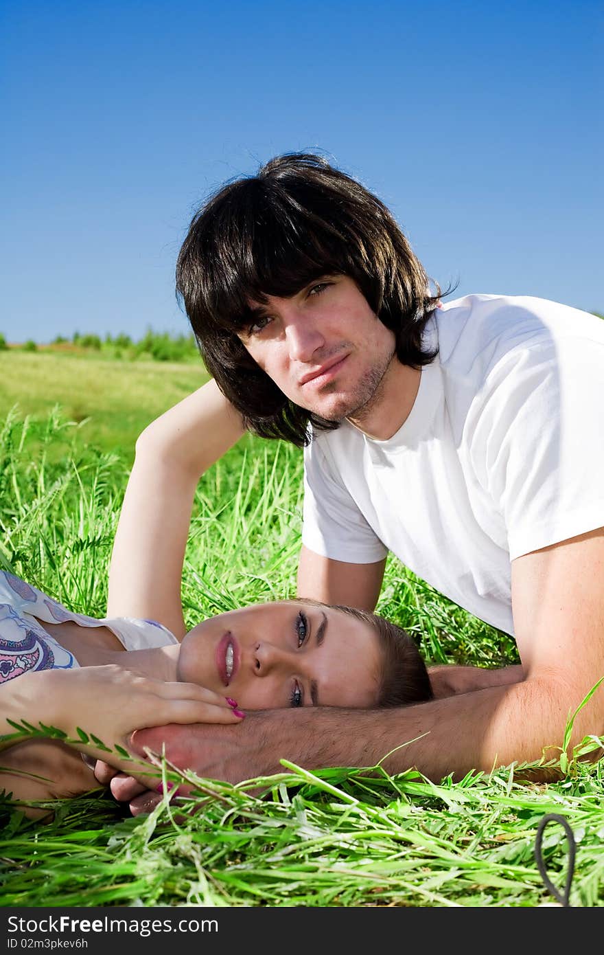 Beautiful girl and boy in white t-shirt on grass. Beautiful girl and boy in white t-shirt on grass