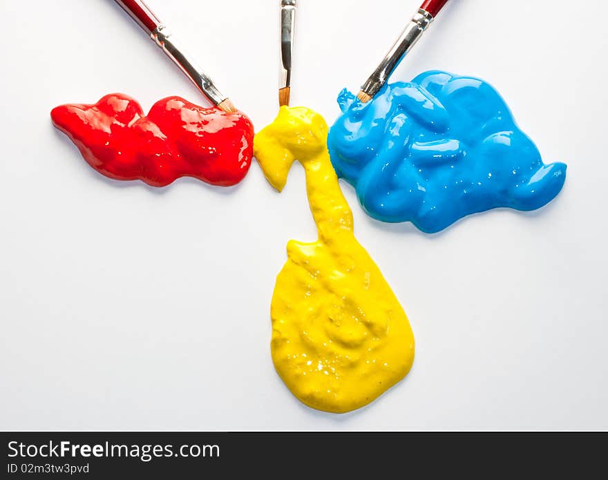 Paintbrushes and red, yellow and blue colors on a white background. Paintbrushes and red, yellow and blue colors on a white background