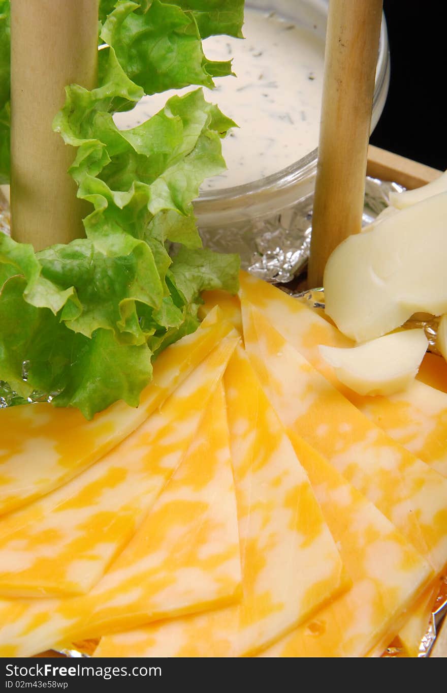 Dutch cheese with white sauce on wooden plate. Closeup