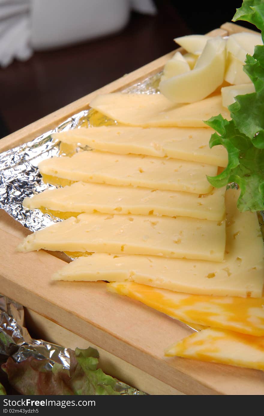 Dutch cheese on wooden plate. Closeup