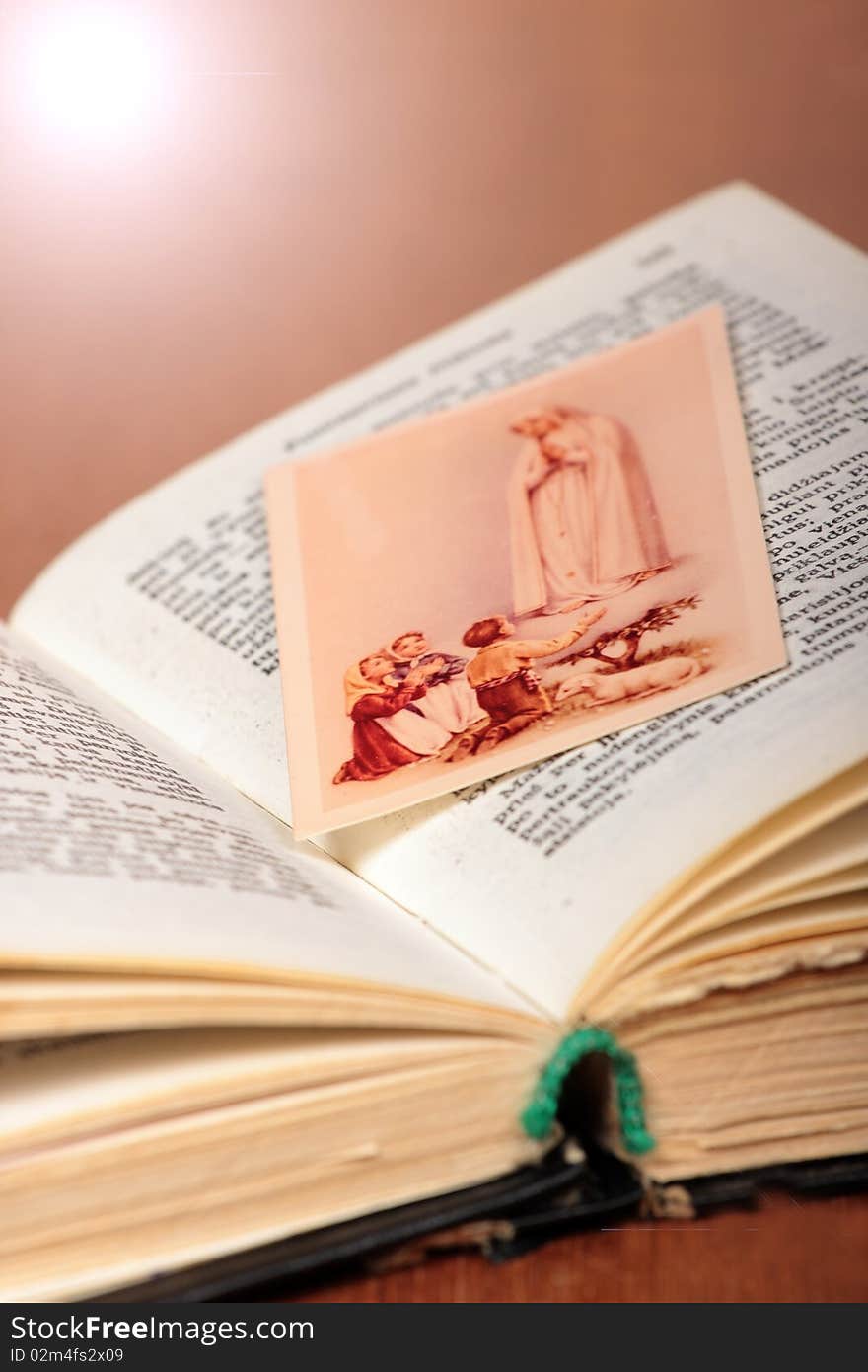 Little picture of children praying to Virgin Marry put between pages of old prayer-book. Little picture of children praying to Virgin Marry put between pages of old prayer-book