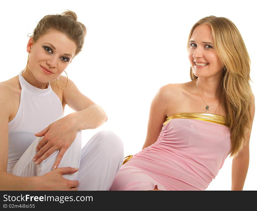 Two young female models relaxing on the floor. Isolated studio shot. Two young female models relaxing on the floor. Isolated studio shot.