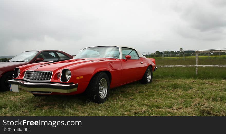 Classic American red car on the grass. Classic American red car on the grass