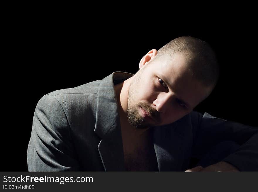 Portrait of bristly man in coat in the dark