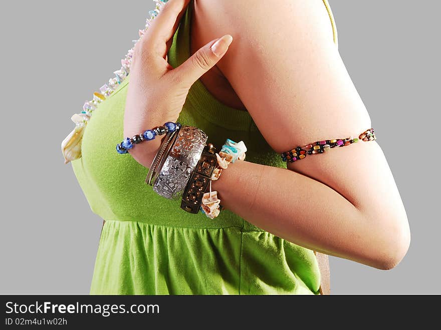 Girl wearing a jewelery in hand isolated on a gray background. Girl wearing a jewelery in hand isolated on a gray background.