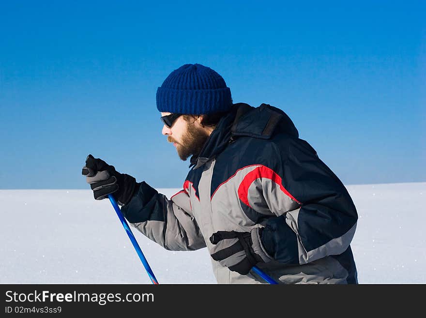 Portrait of handsome skier in the snowy field