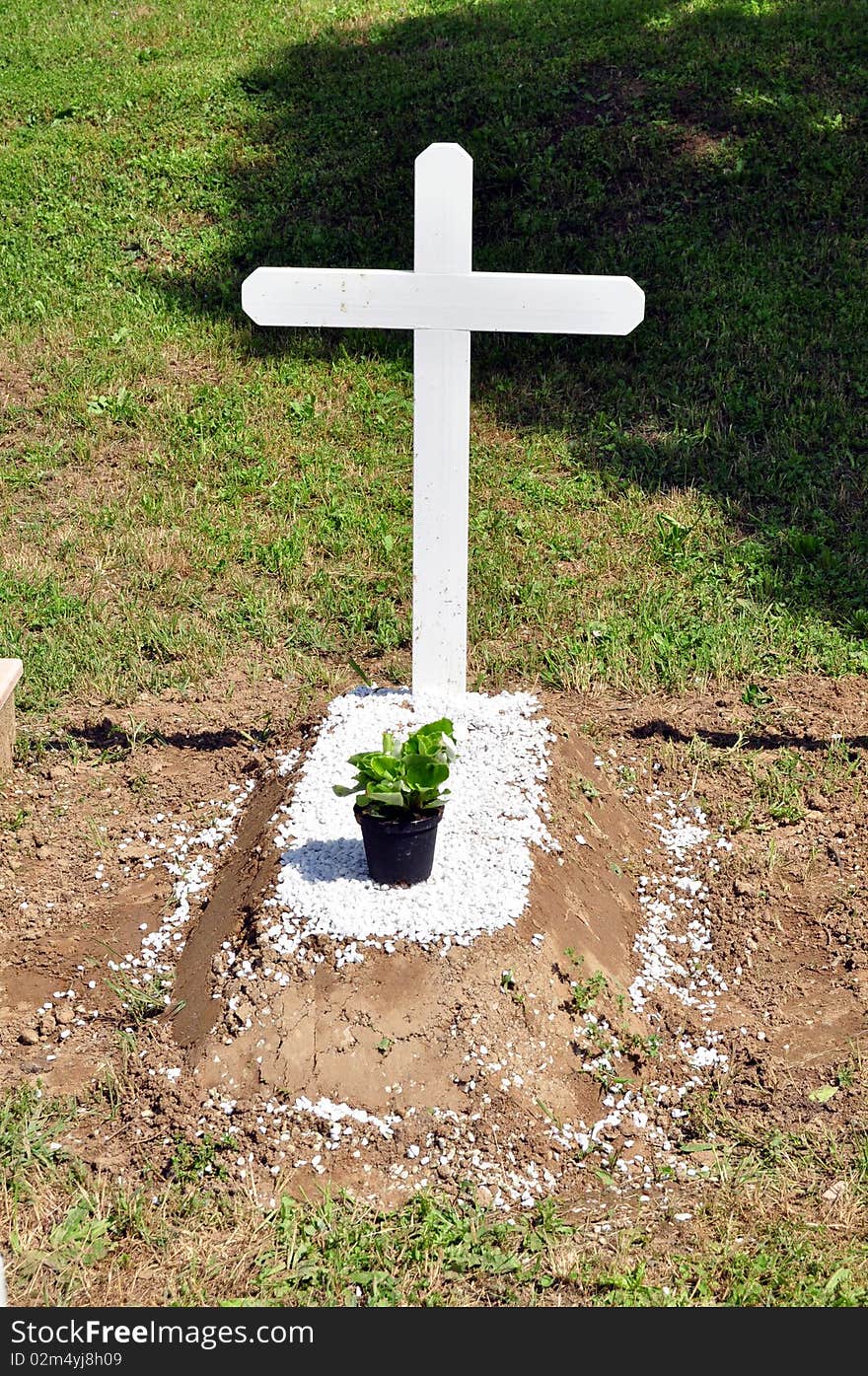 A little tomb with a white cross without name on it. A little tomb with a white cross without name on it