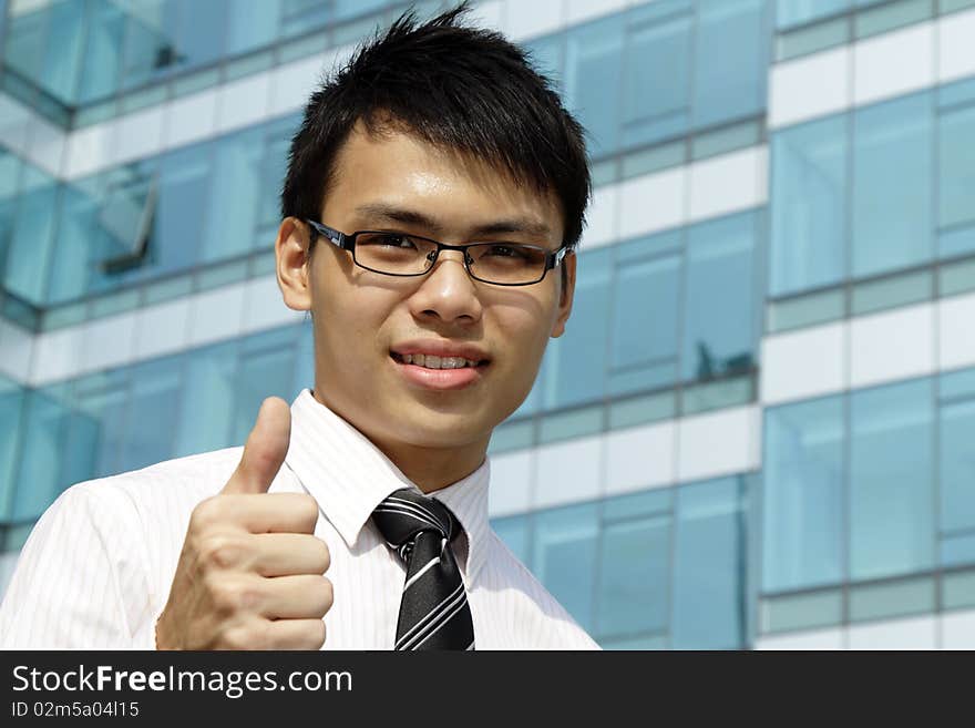 A young Asian business executive showing the thumbs up