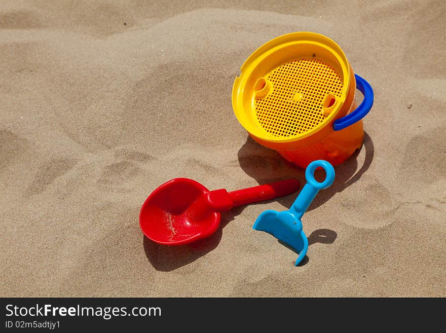 Children's beach toys - buckets, spade and shovel on sand on a sunny day. Children's beach toys - buckets, spade and shovel on sand on a sunny day