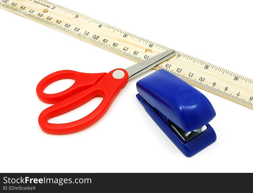 Wooden ruler with red-handle scissor and blue stapler. Wooden ruler with red-handle scissor and blue stapler