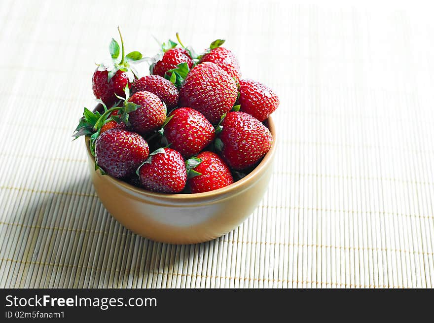 Ripe strawberries in ceramic bowl