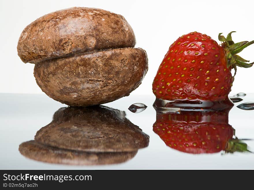 Honey cake and wet fresh strawberry on reflective surface