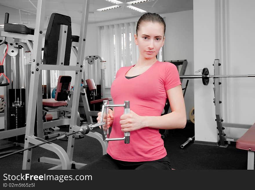 Young woman making physical exercises in a fitness center. Young woman making physical exercises in a fitness center