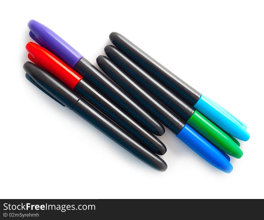 Set of multi-coloured pens on a white background