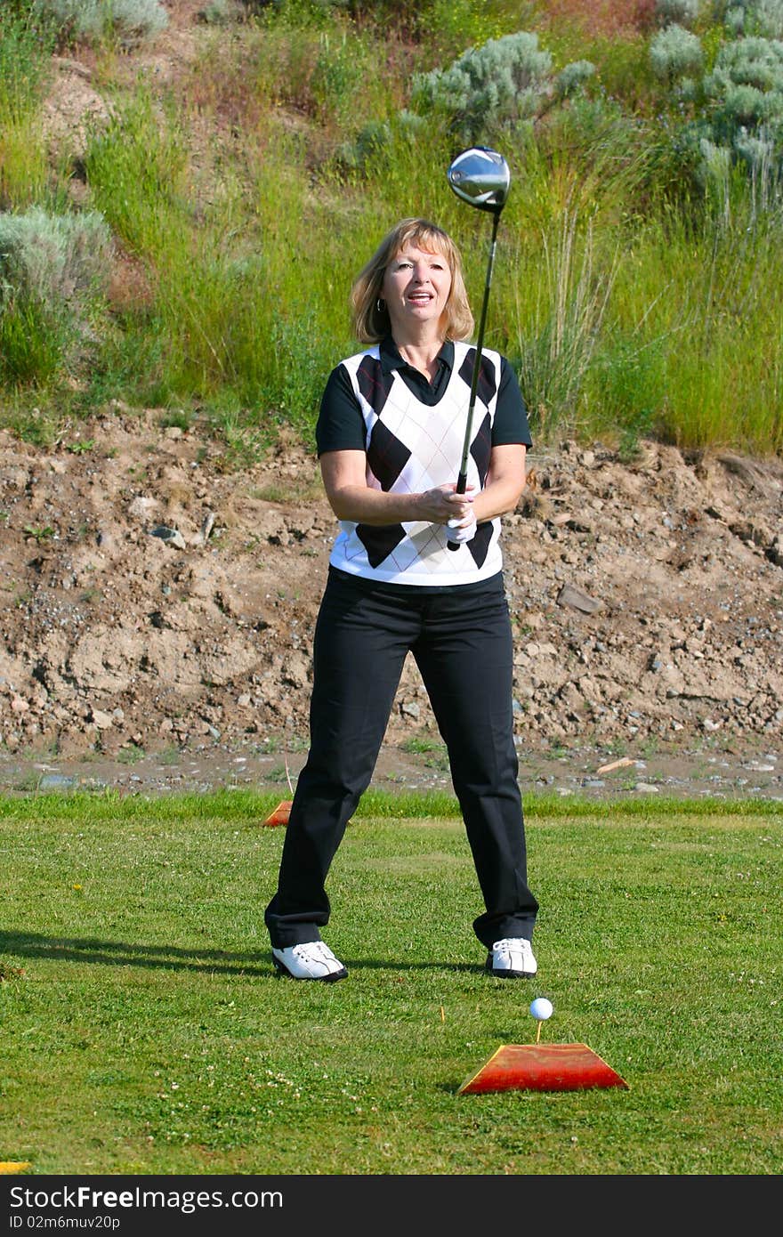 Blond female golfer on the tee-box with a driver