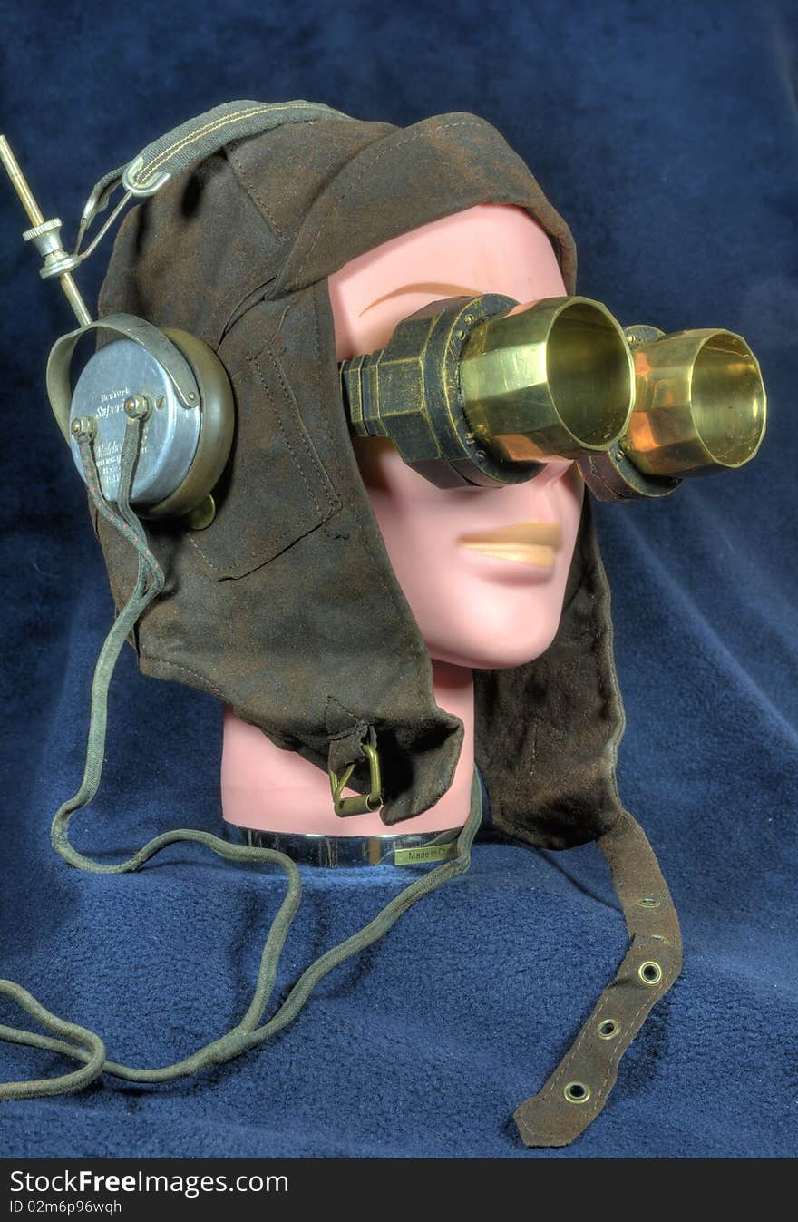 Steampunk image: female mannequin head with vintage pilot's cap, large brass goggles and antique headphones. Steampunk image: female mannequin head with vintage pilot's cap, large brass goggles and antique headphones