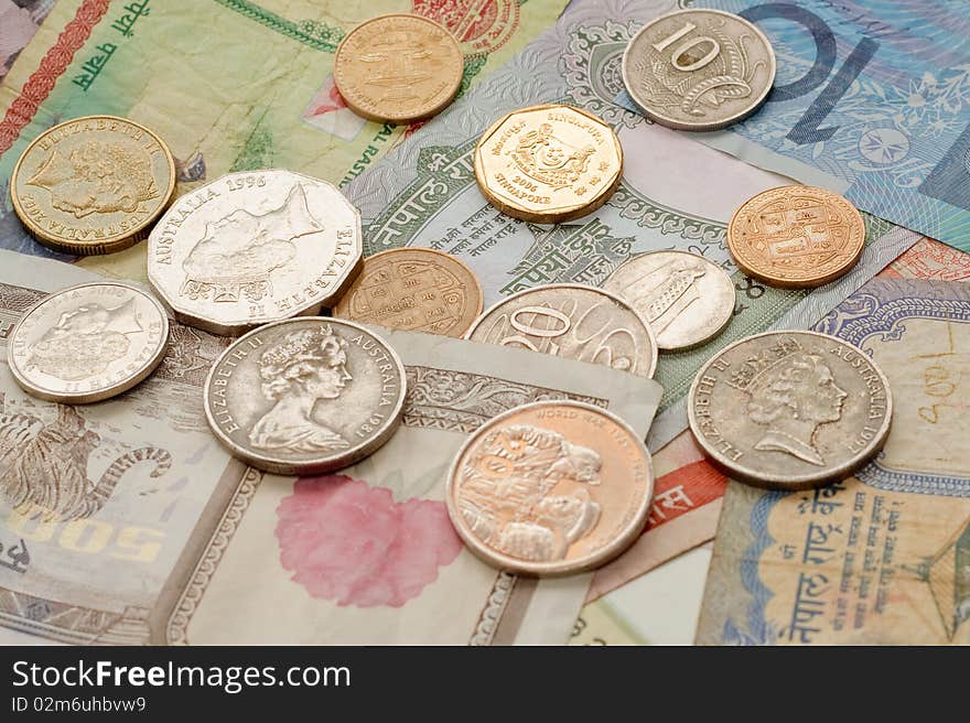 Various international coins and notes spread out across table. Various international coins and notes spread out across table