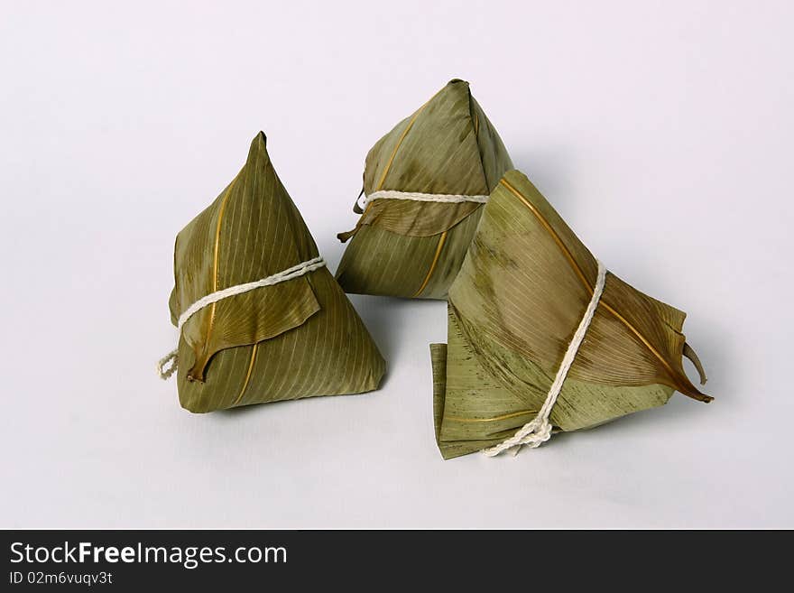 A pyramid-shaped mass of glutinous rice wrapped in leaves. A pyramid-shaped mass of glutinous rice wrapped in leaves